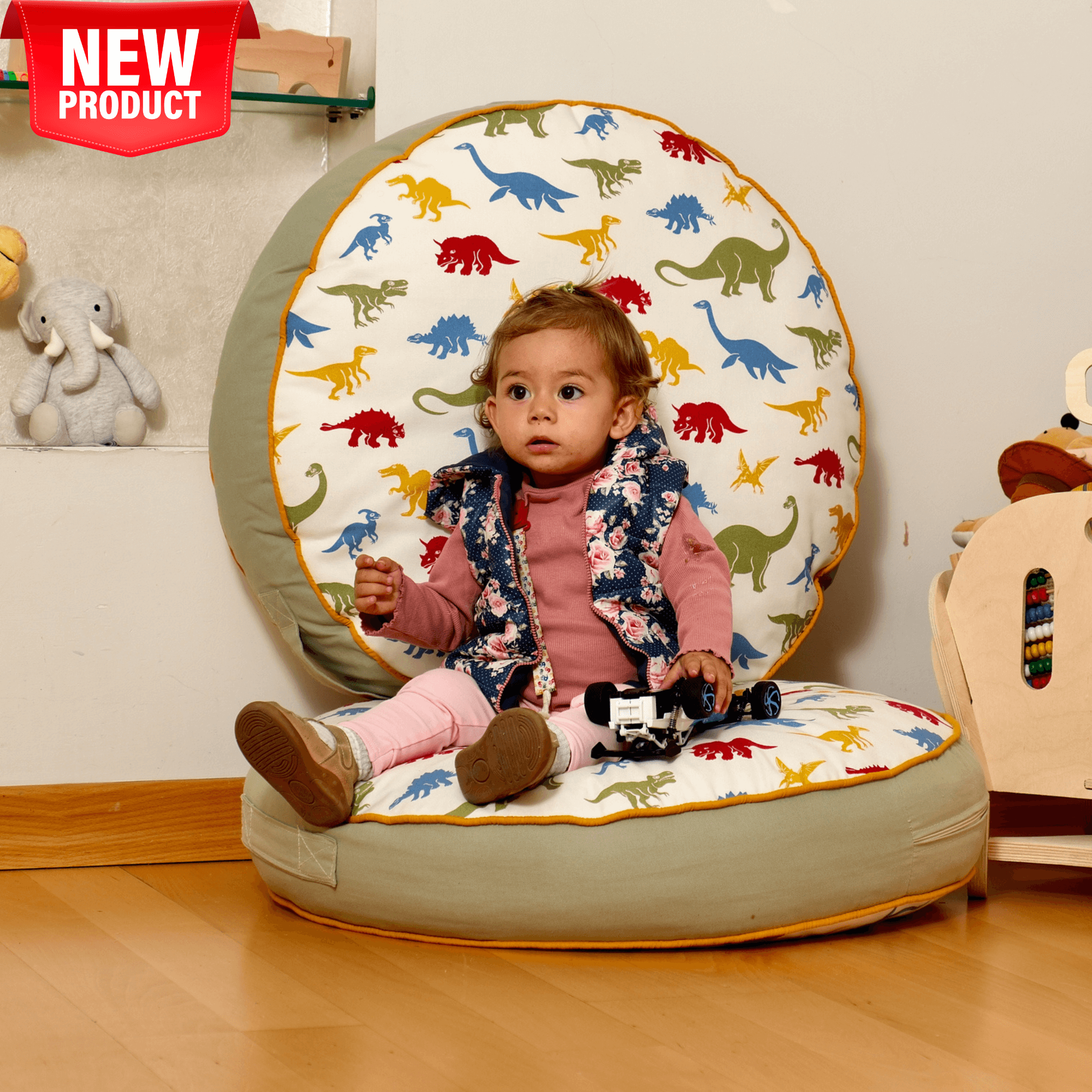 Toddler enjoying a colorful dinosaur floor pillow, perfect for playtime, reading, and Montessori activities.