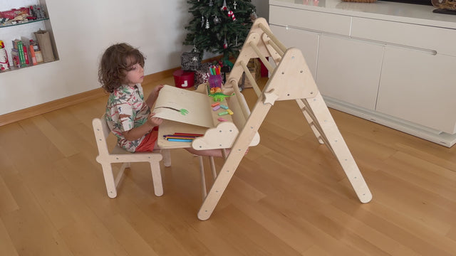 Wooden Pikler triangle with table and chair accessories for toddlers, promoting active play, climbing, and creative learning.