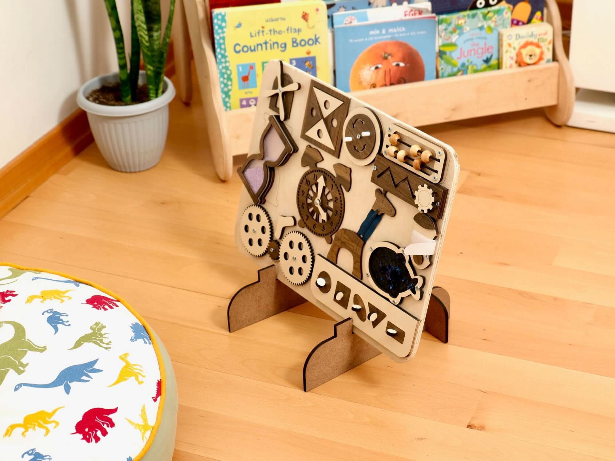 Wooden busy board for toddlers featuring sensory activities like gears, clock, and shapes, ideal for Montessori learning.