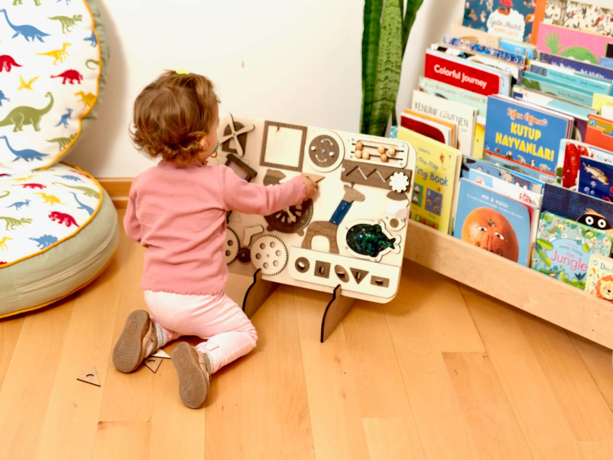 Toddler exploring a Montessori-inspired Wooden Busy Board with engaging sensory activities for hands-on learning.