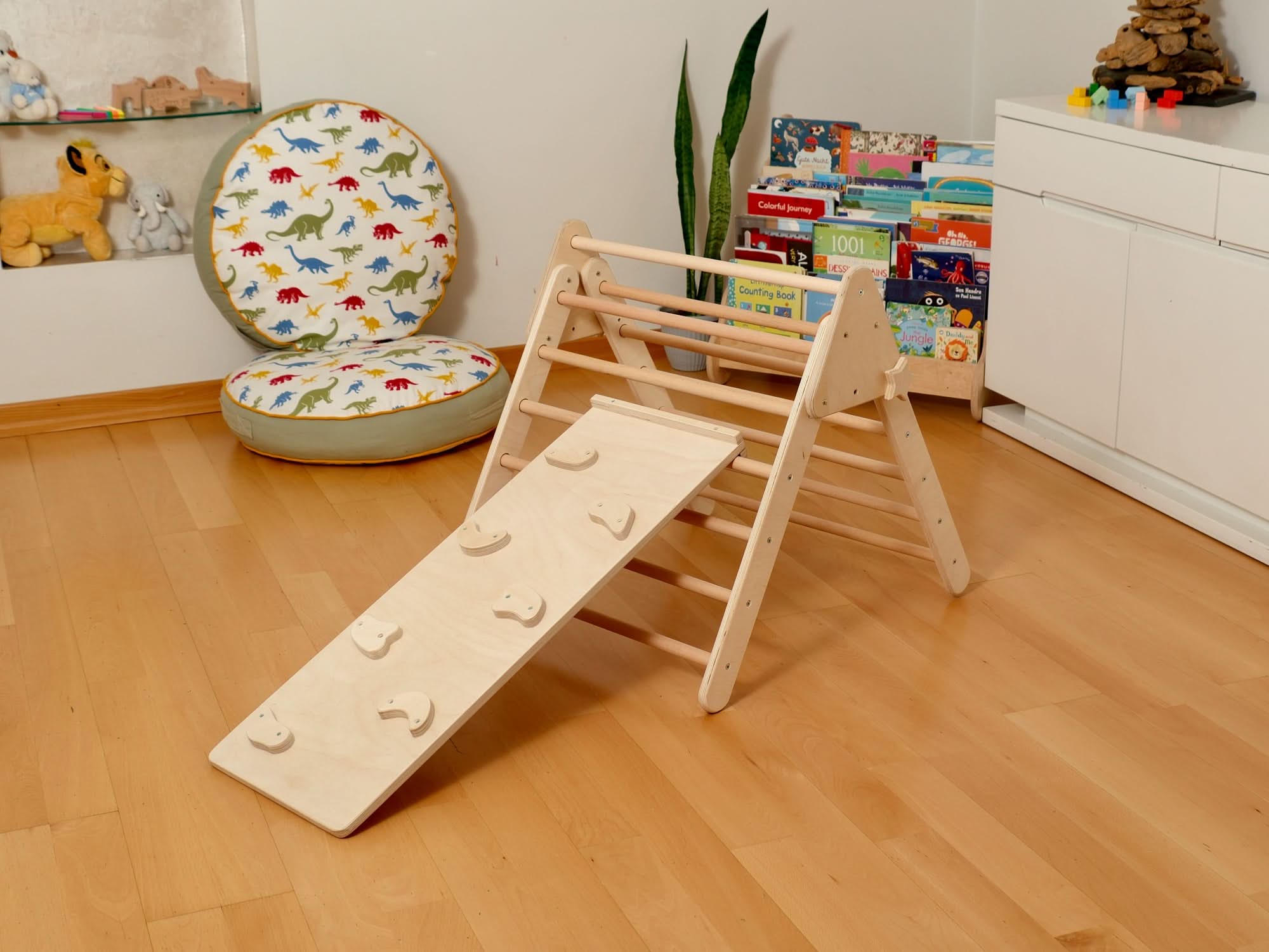 Montessori indoor playground with wooden Pikler triangle and slide for toddlers' fun and learning.