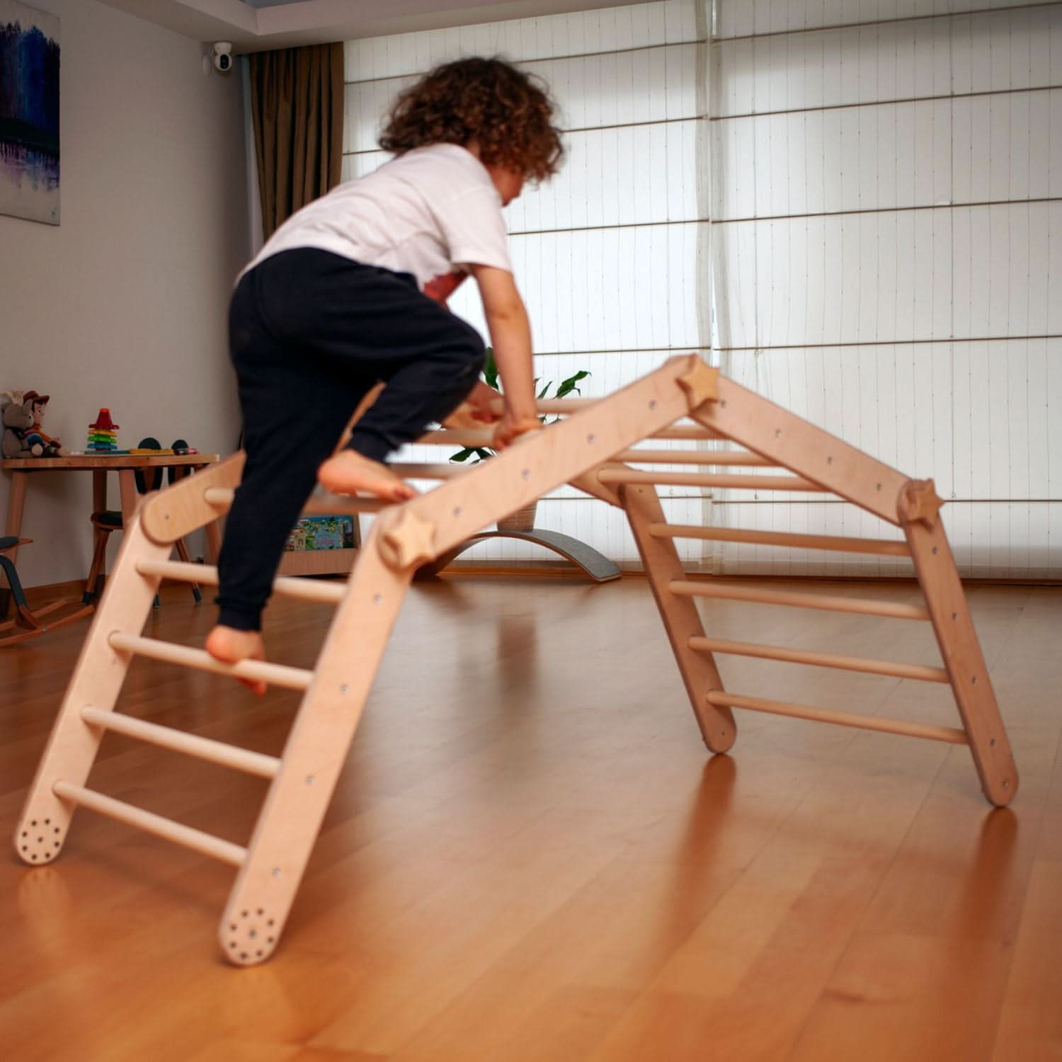 Child climbing a wooden ladder in a home setting