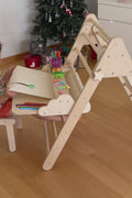 Wooden Pikler triangle with table and chair accessories for toddlers, promoting active play, climbing, and creative learning.